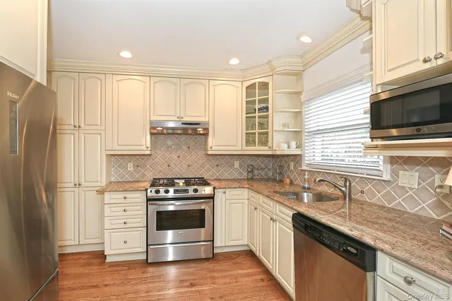 a kitchen with stainless steel appliances granite countertop a stove a sink and a refrigerator