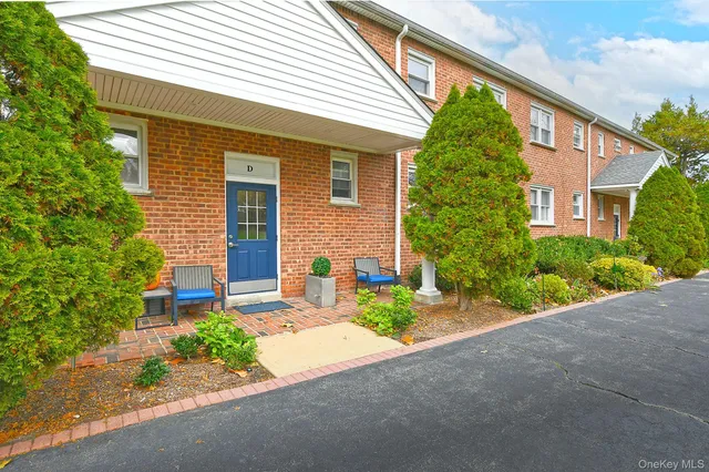a front view of a house with a yard and potted plants