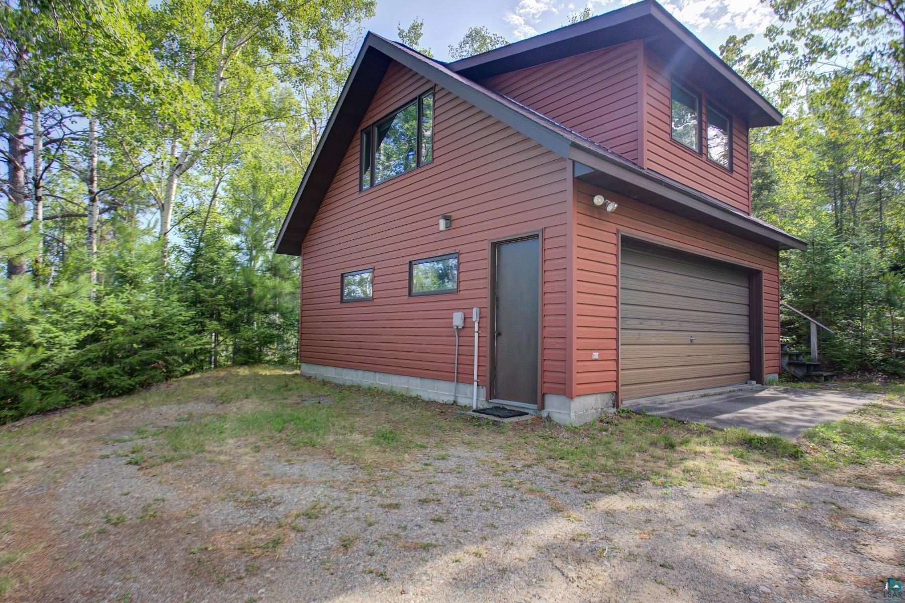 2815 Schaeffer Road Ely, MN 55731 - Photo 17 of 37 Two-story detached structure featuring horizontal siding, a single garage door, and multiple windows