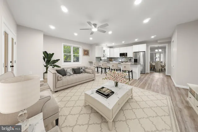 a living room with stainless steel appliances furniture and a view of kitchen