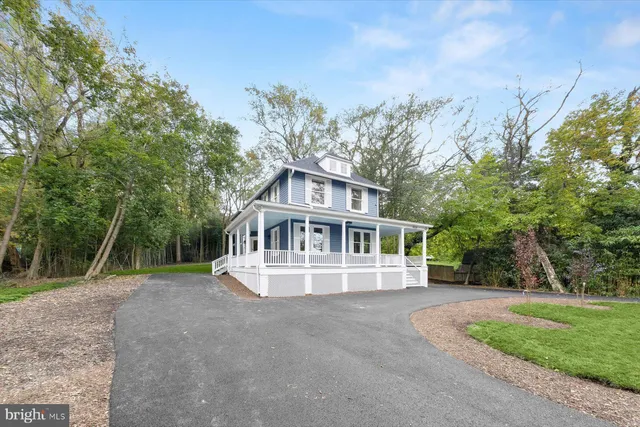 a front view of a house with a yard and trees