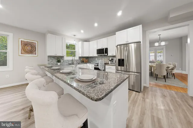 a kitchen with granite countertop stainless steel appliances a refrigerator sink and microwave