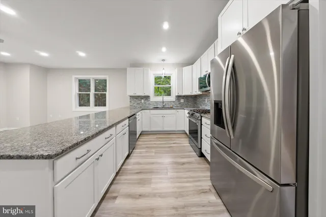 an empty room with windows and ceiling fan