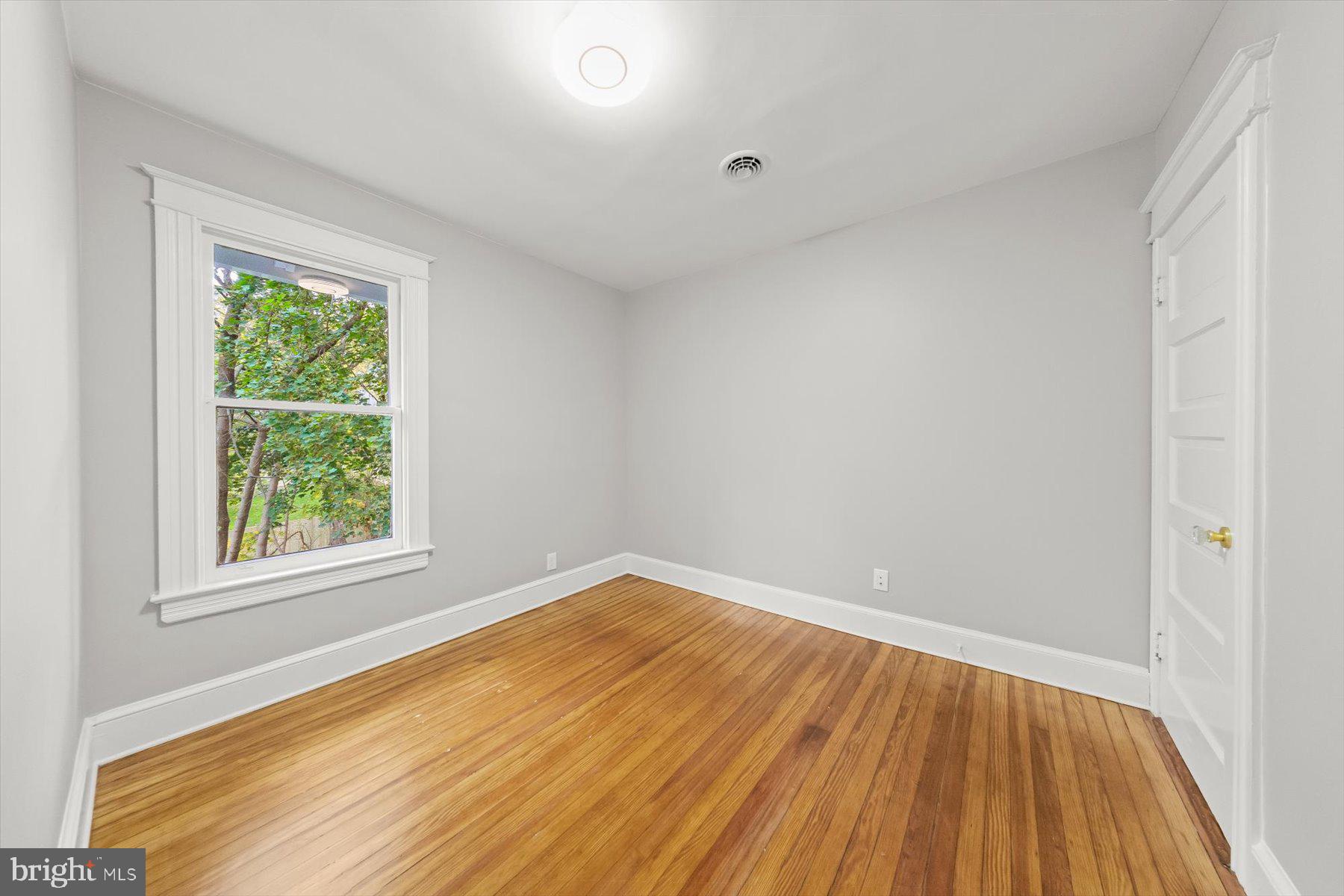 10220 Capitol View Avenue Silver Spring, MD 20910 - Photo 54 of 66 an empty room with wooden floor and windows
