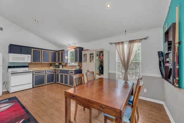 a large kitchen with a table and chairs in it