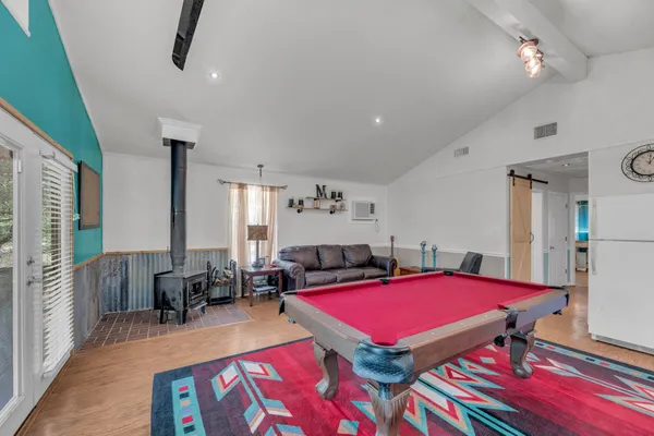 a room with furniture pool table and windows