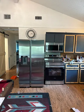 a kitchen with kitchen island granite countertop wooden cabinets and stainless steel appliances
