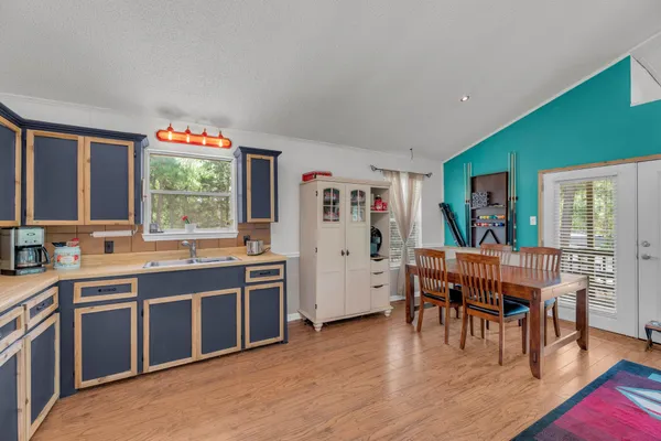 a large kitchen with stainless steel appliances granite countertop a stove and a dining table