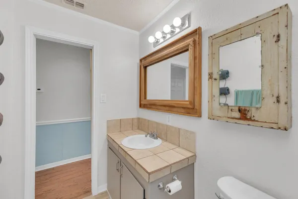 a bathroom with a granite countertop sink toilet a mirror and shower