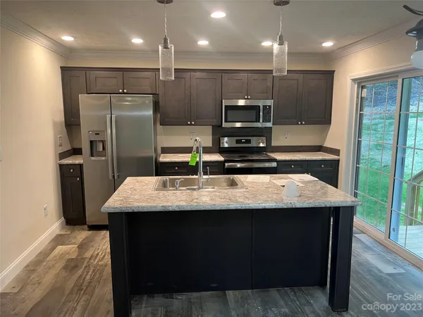 a kitchen with kitchen island stainless steel appliances a sink stove and refrigerator