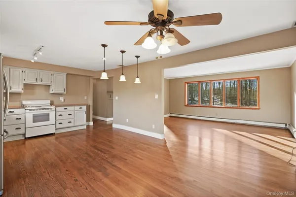 a view of a kitchen with wooden floor and a window