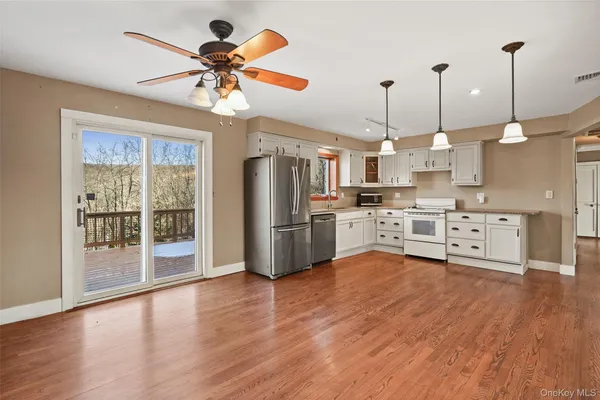 a kitchen with stainless steel appliances kitchen island granite countertop a stove a refrigerator a oven a sink with a dining table and chairs