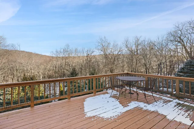 a view of a balcony with wooden floor and trees