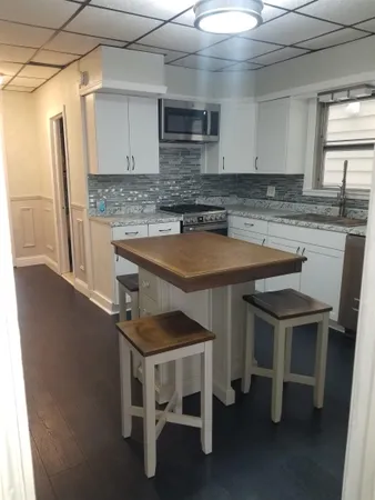 a kitchen with a table chairs sink and cabinets