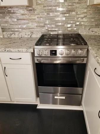 a stove top oven sitting inside of a kitchen