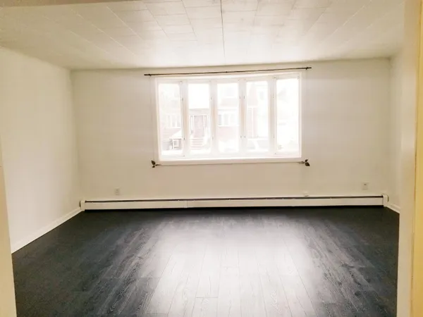 an empty room with wooden floor and a window