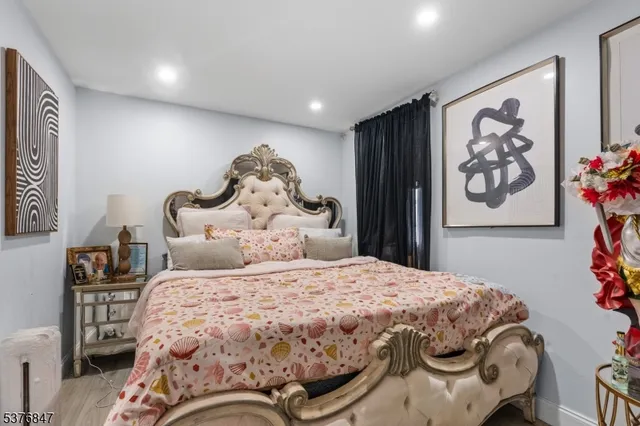 a bedroom with a bed and painting on the wall