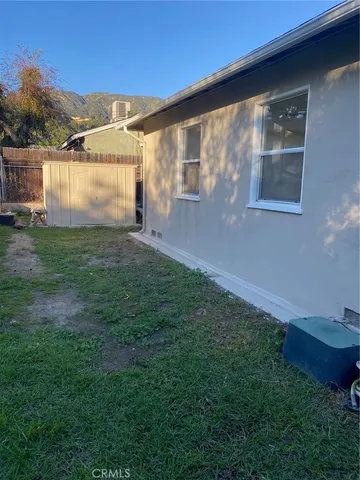 a view of a back yard of the house with a yard