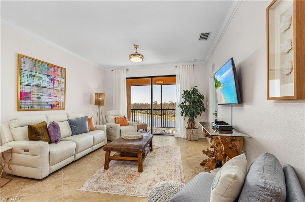 9731 Acqua Court, Unit 543 Naples, FL 34113 - Photo 11 of 24 a living room with furniture and a flat screen tv
