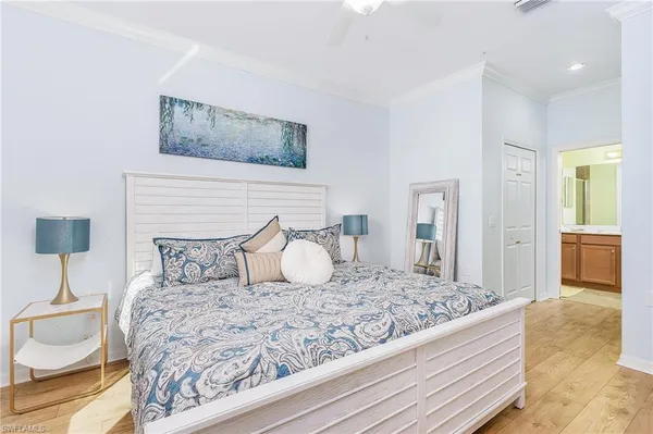 a bedroom with a bed and a lamp on dresser