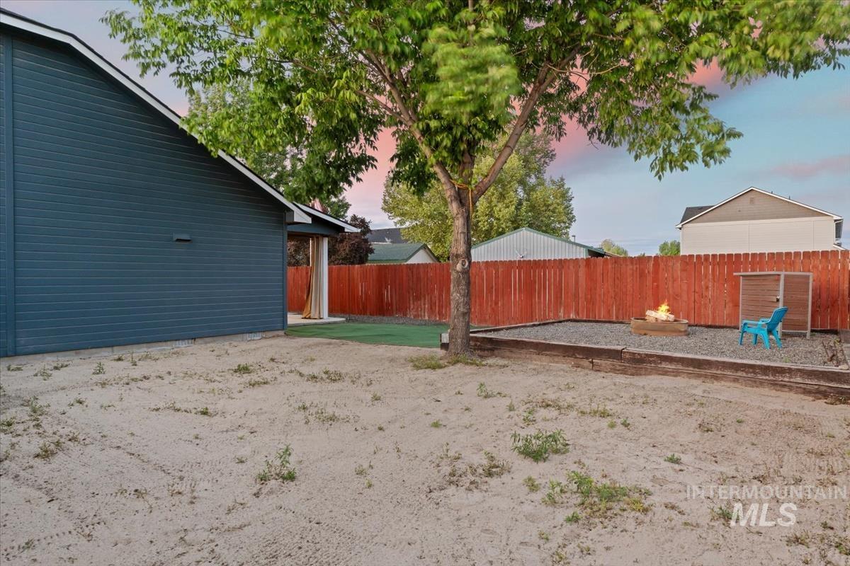 80 Cobblestone Court Middleton, ID 83644 - Photo 27 of 48 Expansive backyard featuring a gravel fire pit area with timber border, a mature shade tree, and a covered patio with pillars