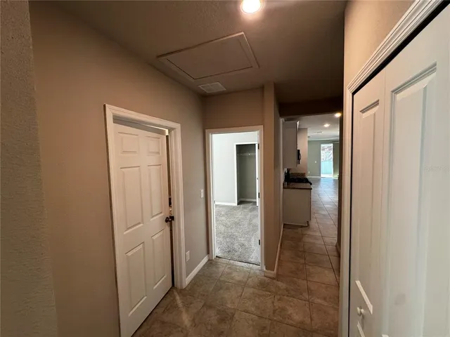 a view of a hallway with wooden floor and a bathroom