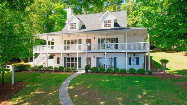 a front view of a house with a yard and trees