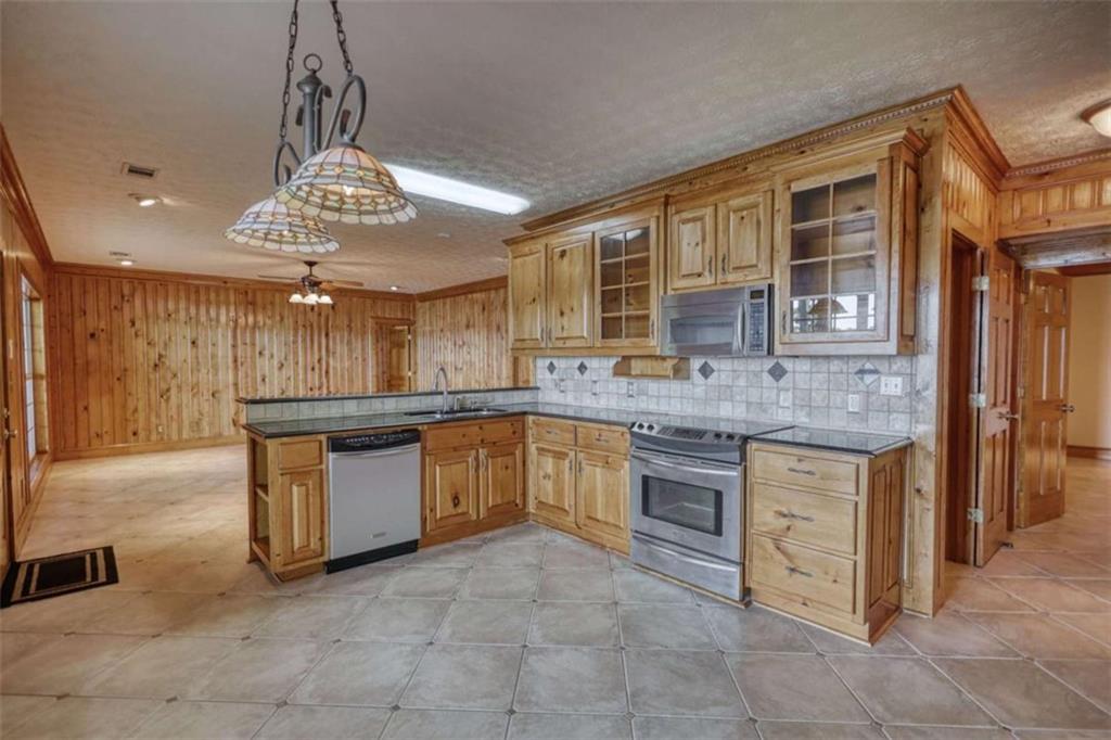 255 Old Hardy Farm Road Jackson, GA 30233 - Photo 33 of 78 a kitchen with stainless steel appliances granite countertop a stove refrigerator and cabinets