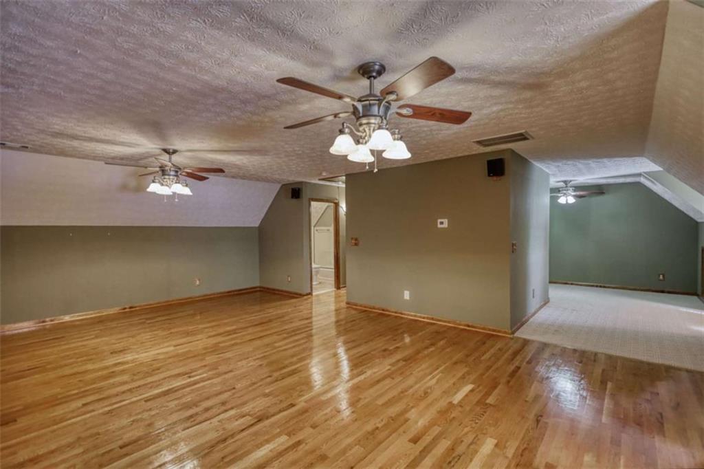 255 Old Hardy Farm Road Jackson, GA 30233 - Photo 35 of 78 an empty room with wooden floor chandelier fan and windows