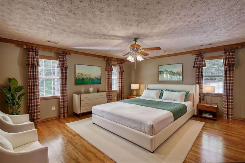 255 Old Hardy Farm Road Jackson, GA 30233 - Photo 47 of 78 a bedroom with a large bed a flat tv screen and a potted plant