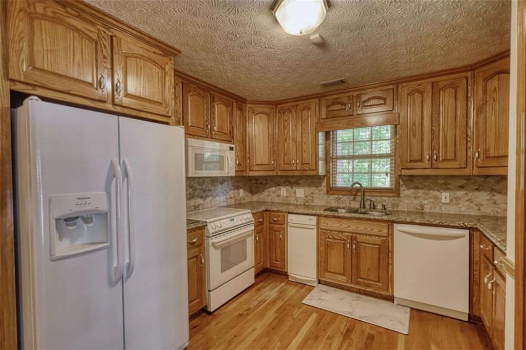 255 Old Hardy Farm Road Jackson, GA 30233 - Photo 55 of 78 a kitchen with stainless steel appliances granite countertop a sink a stove a refrigerator cabinets and a window
