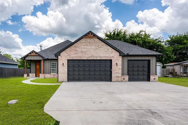 a view of a house with a yard and large trees