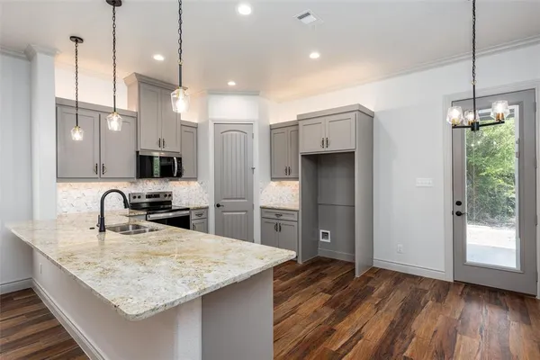 a large white kitchen with stainless steel appliances granite countertop a stove a sink and a refrigerator