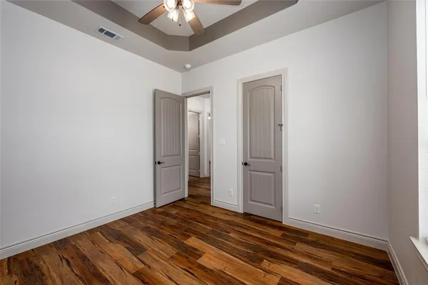 a bathroom with a granite countertop toilet sink and mirror