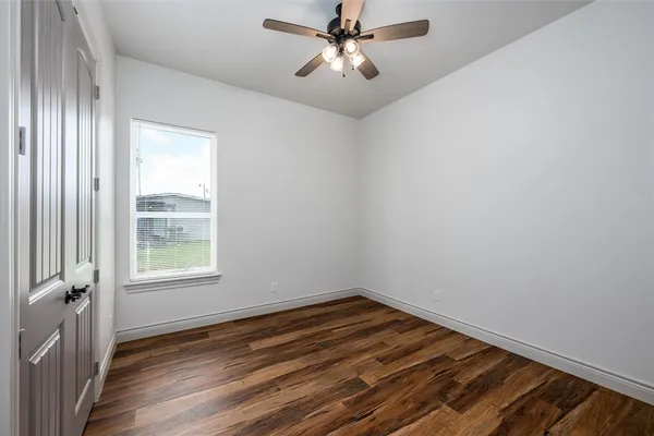 a view of a livingroom with wooden floor and a ceiling fan