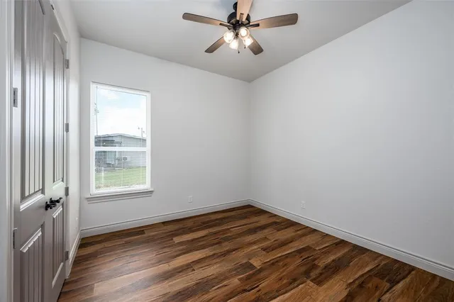 a view of a livingroom with wooden floor and a ceiling fan