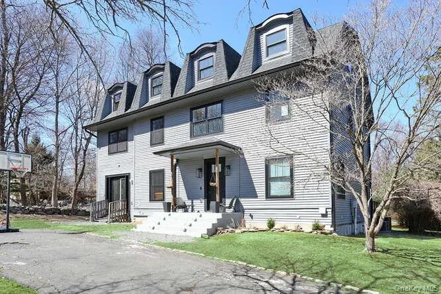 a view of a white house with a large windows and a large tree
