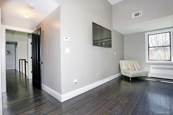 a view of a room with wooden floor and a window