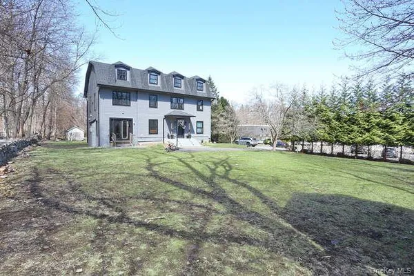 a view of a big house with a big yard and large trees