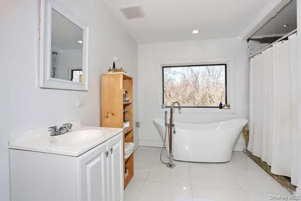 a bathroom with a sink and mirror with window