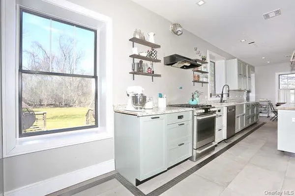 a kitchen with a stove a sink and a window