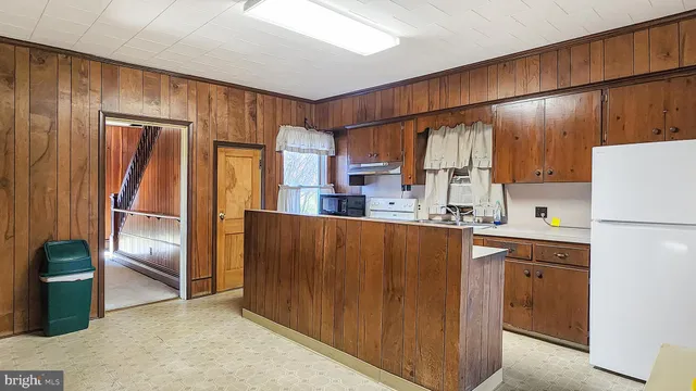 a kitchen with kitchen island wooden cabinets a refrigerator and a sink