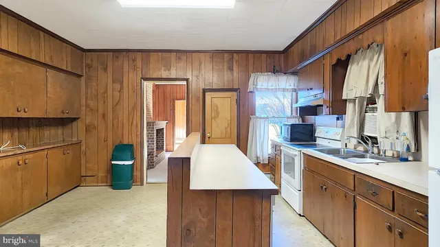 a kitchen with a sink a refrigerator and cabinets