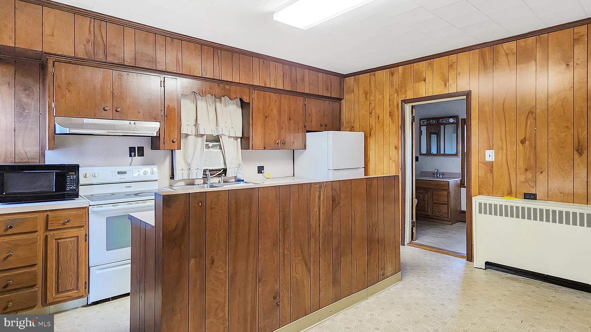 2431 Tulls Corner Road Pocomoke City, MD 21851 - Photo 6 of 28 a kitchen with kitchen island cabinets and wooden floor