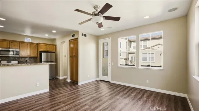 a view of an empty room with kitchen appliances and a window