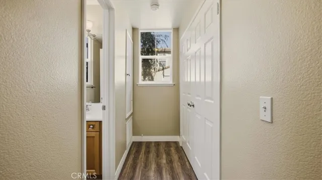 a view of a hallway with wooden floor and closet