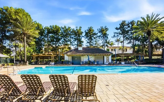 a patio with table and chairs and potted plants