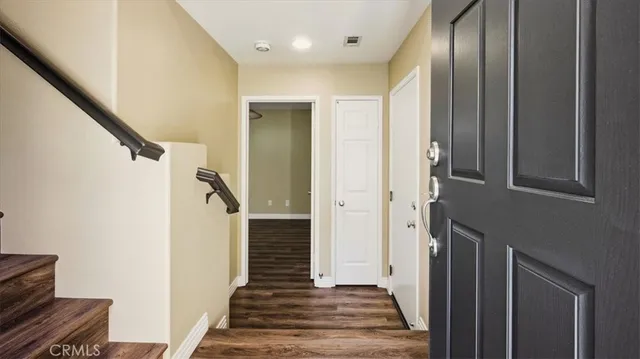 a view of a hallway with wooden floor and staircase