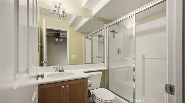 a bathroom with a granite countertop sink toilet mirror and shower