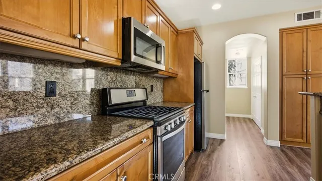a kitchen with stainless steel appliances granite countertop a stove a refrigerator and a microwave